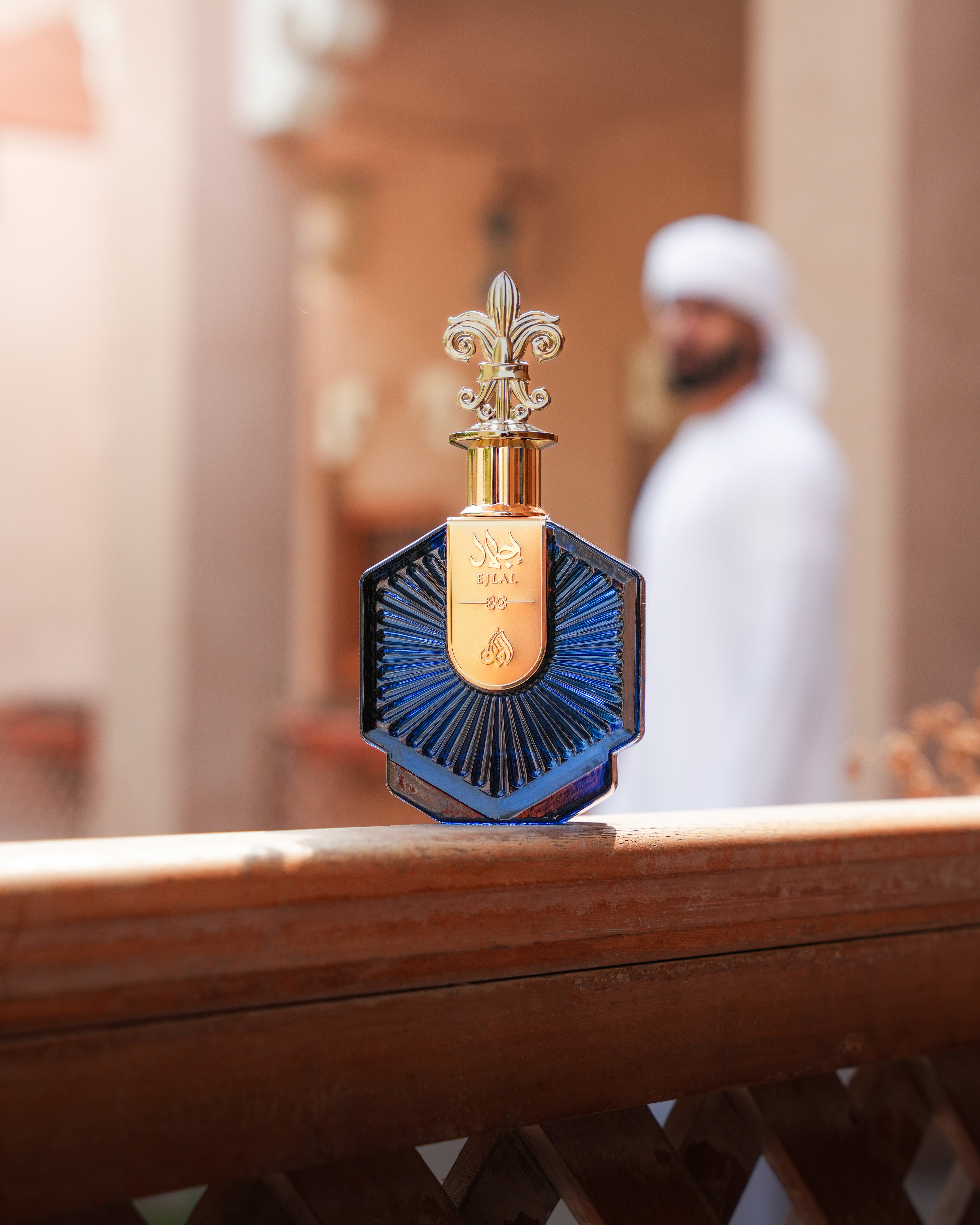 Perfume bottle with intricate design on a wooden surface, blurred background