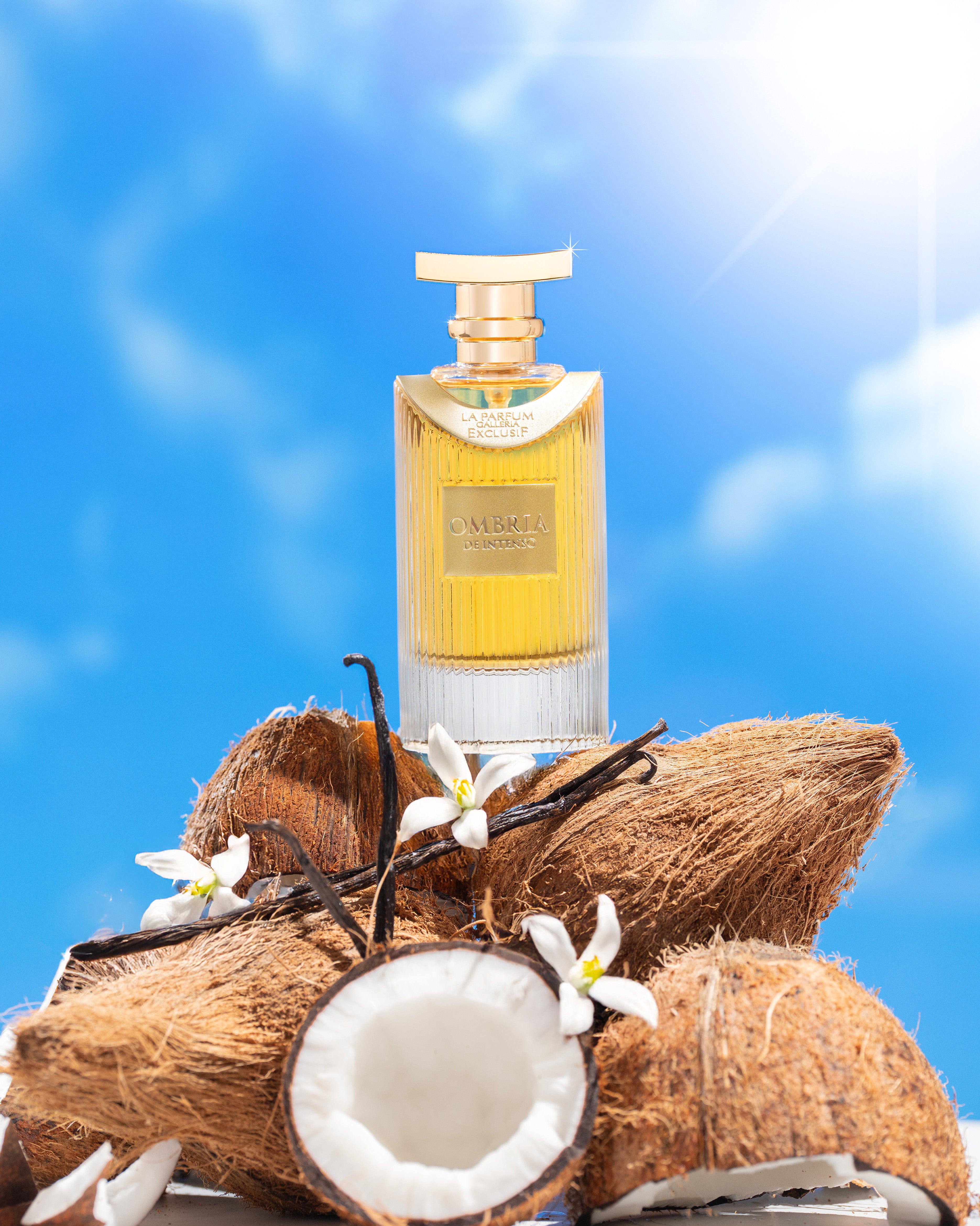 Perfume bottle with coconuts and vanilla flowers against a blue sky background